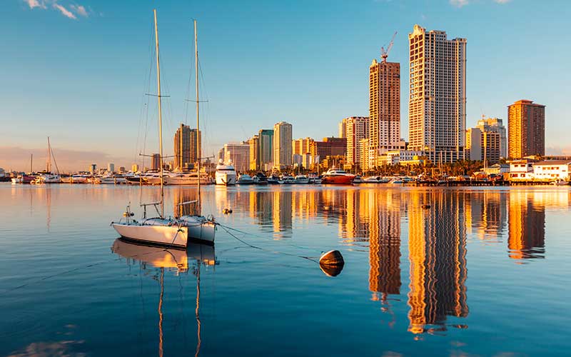 Manila’s skyline reflected in the calm waters of Manila Bay, Philippines. Image source: iStock