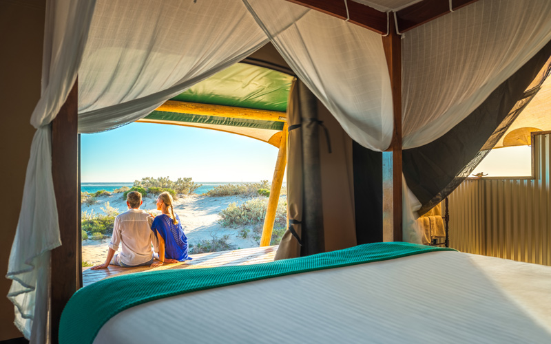 Couple relaxing outside their deluxe tent in Sal Salis Ningaloo Reef