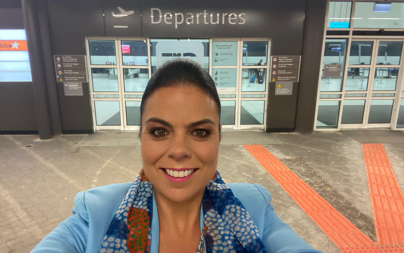 Carolyn Turnbull, Perth Airport Chief Aviation Business Development Officer, at departures sign at Perth Airport